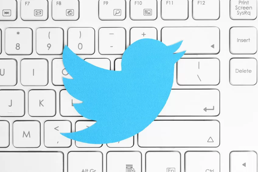 39070379 - kiev, ukraine - april 15, 2015: twitter logotype printed on paper and placed on white keyboard. twitter is an online social networking service that enables users to send and read short messages.