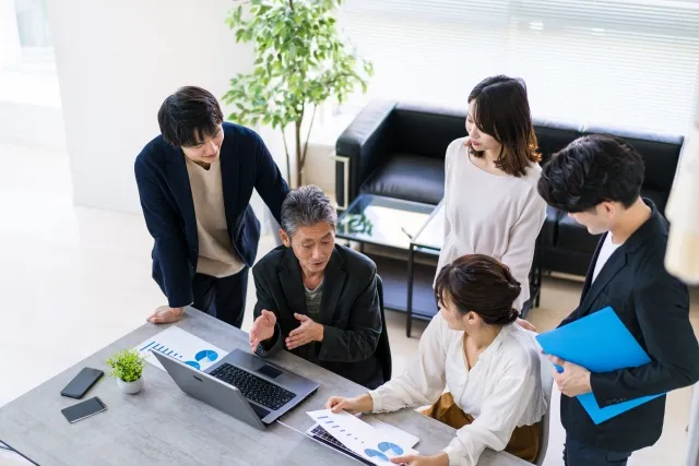 楽しげに4人の部下に研修をしている上司